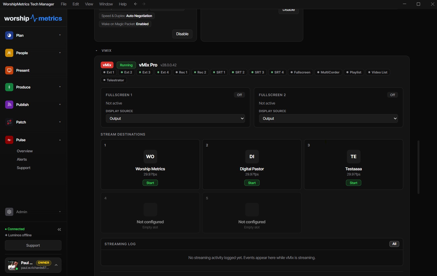 The vMix section of a machine's page in WorshipMetrics Tech Manager: vMix Pro running with status pills for external outputs, recorders, and SRT, two fullscreen output cards with display source pickers, stream destination slots with start buttons, and the streaming log panel